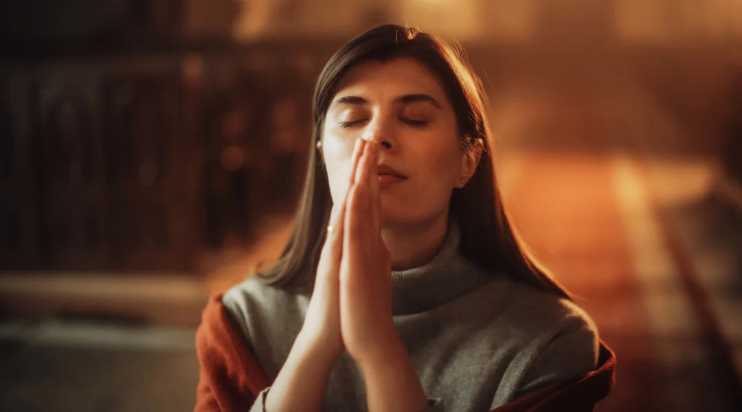 A woman kneels in prayer inside a church, seeking spiritual connection and guidance to strengthen her faith.
